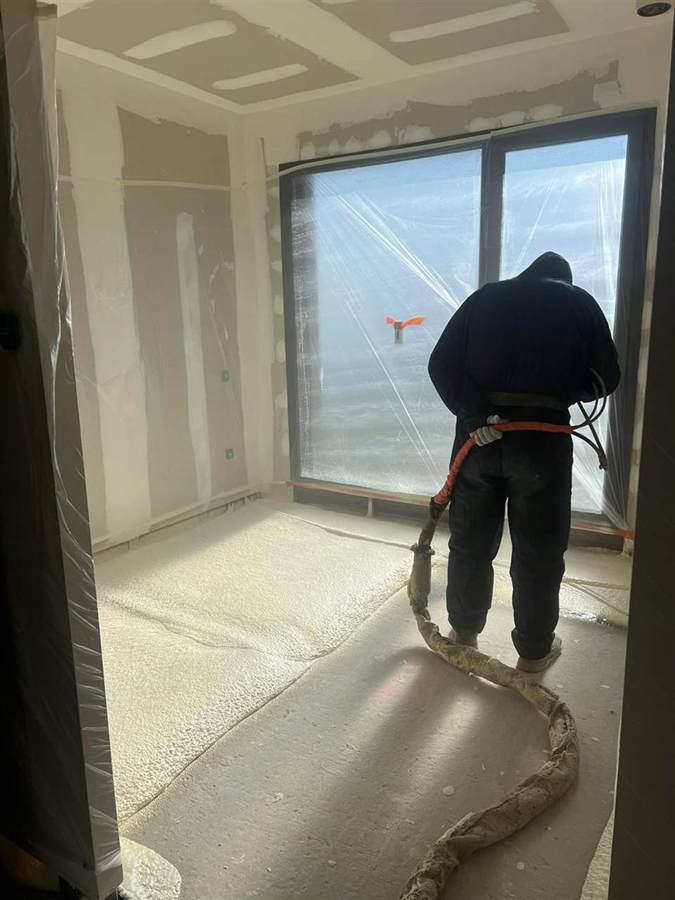 Technicien Gonen Isolation projetant la mousse polyuréthane sur un sol
